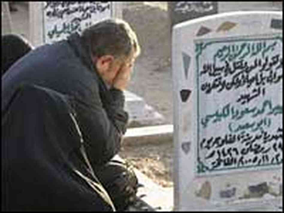 A man in Fallujah weeps at the grave of his loved one A man in Fallujah weeps at the grave of his loved one