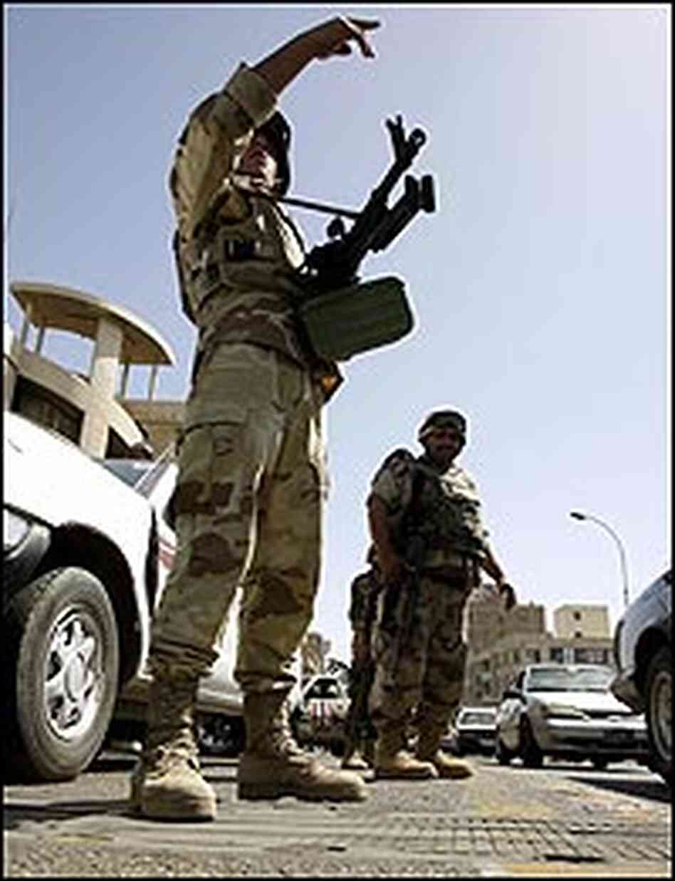 An Iraqi soldier gestures as he mans a checkpoint in central Baghdad. An Iraqi soldier gestures as he mans a checkpoint in central Baghdad.