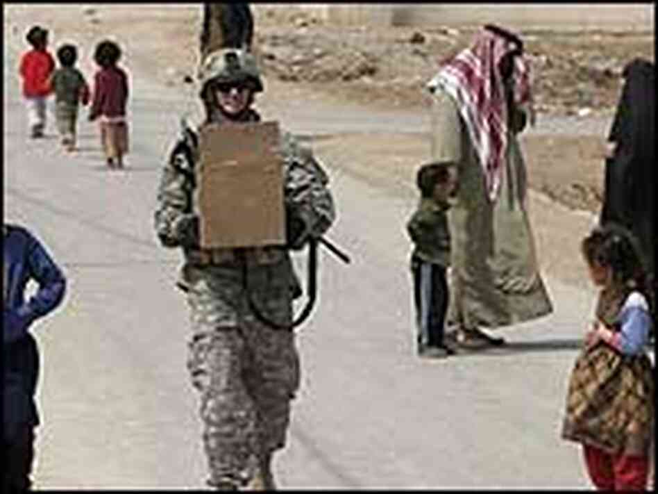 A U.S soldier carries a box of goodies for distribution to children while on a routine patrol. A U.S soldier carries a box of goodies for distribution to children while on a routine patrol.