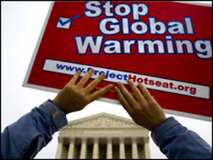 An environmental activist lifts a sign outside the Supreme Court,