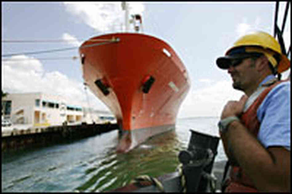 A tug boat docks near a cargo ship at the Port of Miami. A tug boat docks near a cargo ship at the Port of Miami.