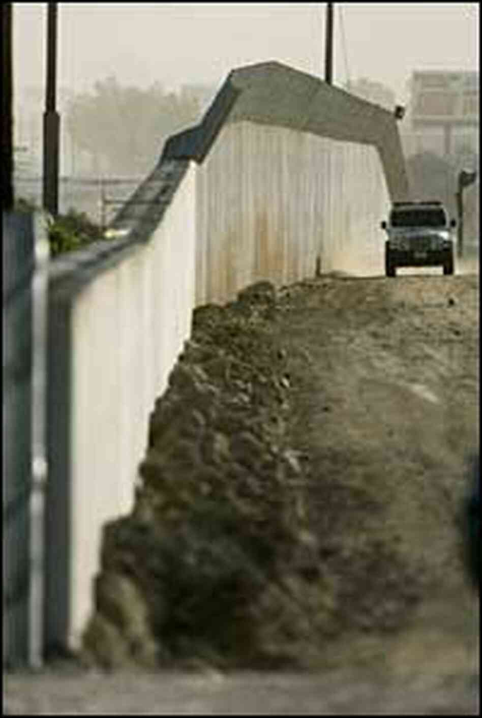 A Customs and Border Protection agent drives along the border wall in San Ysidro, Calif. A Customs and Border Protection agent drives along the border wall in San Ysidro, Calif.