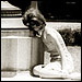 A woman cowers in fear behind a statue at the University of Texas during a campus shooting incident in 1966.