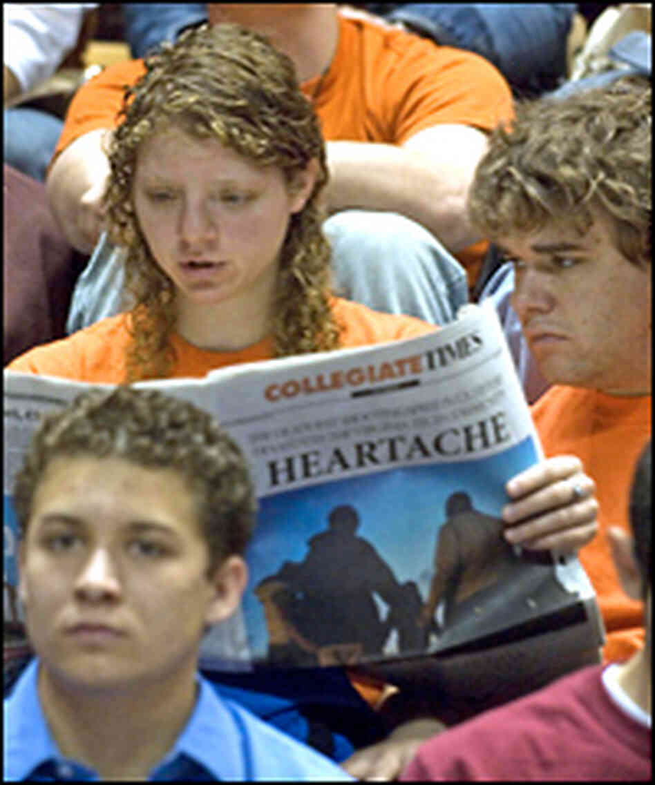 Students read their school newspaper prior to a convocation and memorial. Students read their school newspaper prior to a convocation and memorial.