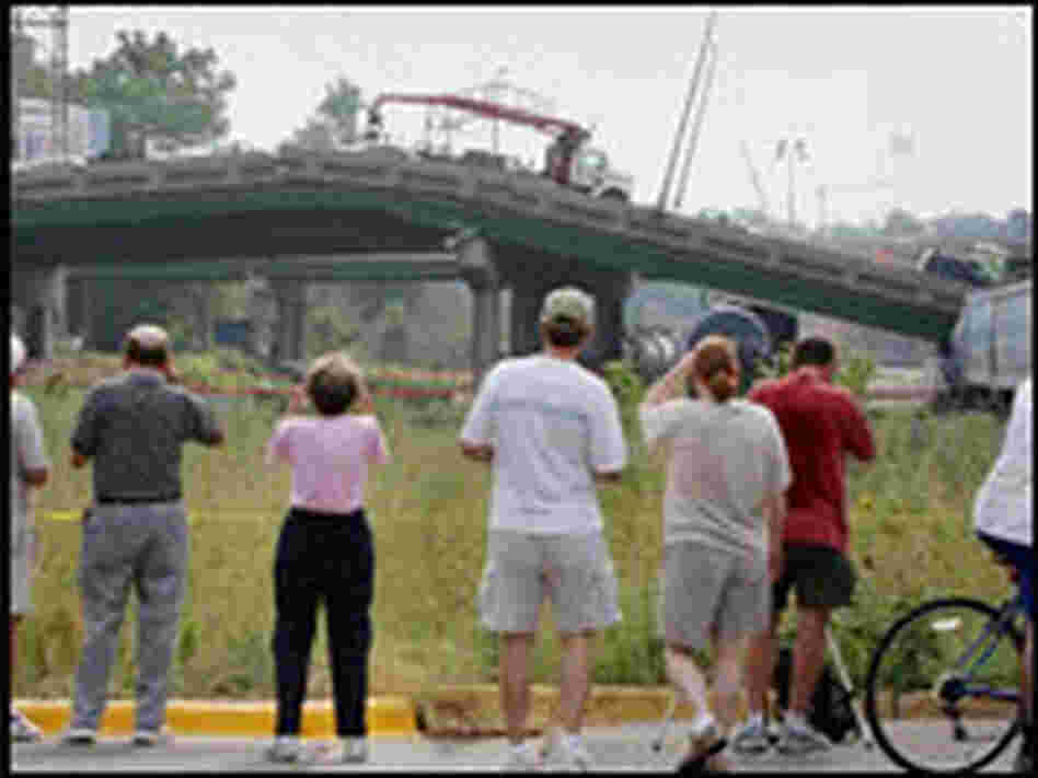 Spectators get a glimpse of the collapsed I-35W bridge after local authorities blocked closer access