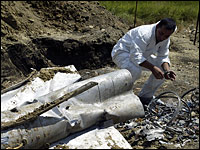 A Georgian specialist examines the remains of the rocket that fell from the sky in Tsitelubani, South Ossetia.