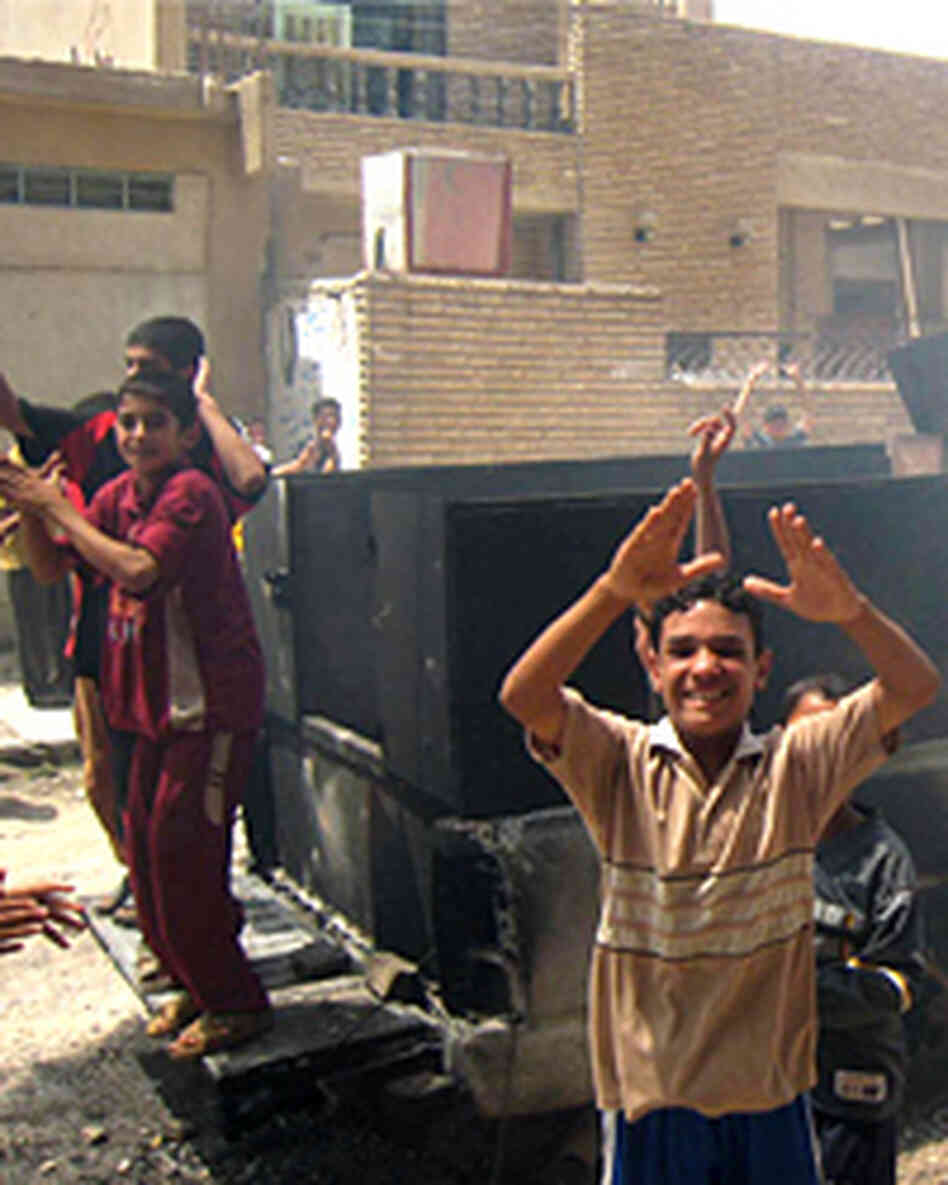 Iraqi youths jubilate at the scene where a roadside bomb targeted an interior ministry forces convoy Iraqi youths jubilate at the scene where a roadside bomb targeted an interior ministry forces convoy