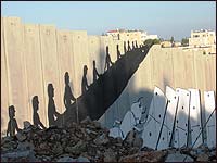 A silhouette of children riding an escalator up and over the wall is one of many pieces of artwork painted on the barrier wall between Bethlehem and Jerusalem.