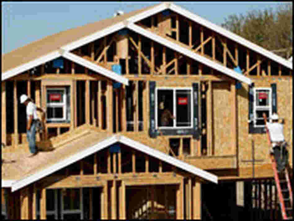 Workers install windows on a new home.