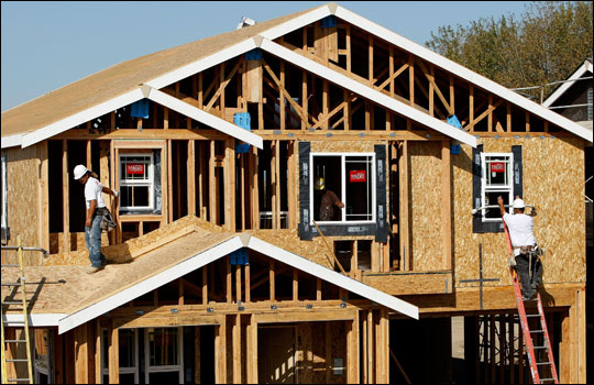 Workers install windows on a new home.