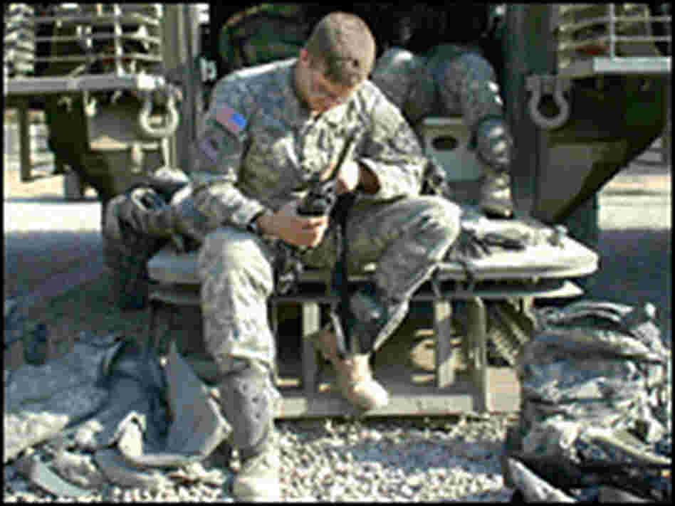 A U.S. soldier from the 5-20 Infantry Division cleans his rifle on the ramp of his Striker.