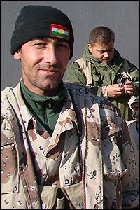 A Kurdish soldier proudly wears a wool cap with the flag of Kurdistan on it.
