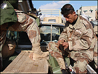 A Kurdish soldier loads the ammunition belt of his machine gun.