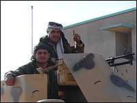 Kurdish soldiers give a thumbs up before setting out in a 60-vehicle convoy to Baghdad.