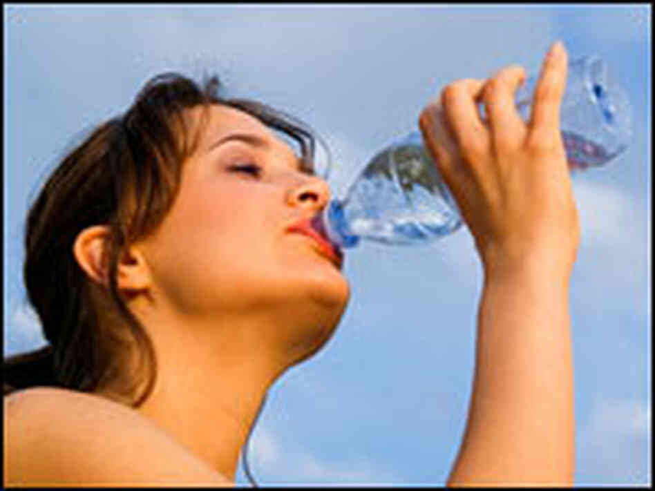 A woman drinks bottled water. A woman drinks bottled water.