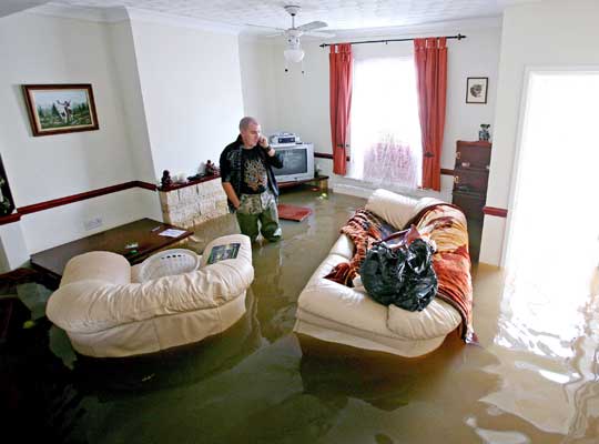 Gloucester resident in flooded home/Getty.