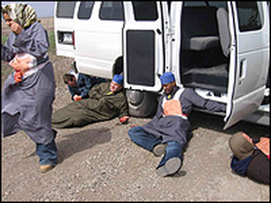 Contractors pretend to be wounded Iraqis during a practice truck bombing on a Kansas gravel road. Contractors pretend to be wounded Iraqis during a practice truck bombing on a Kansas gravel road.