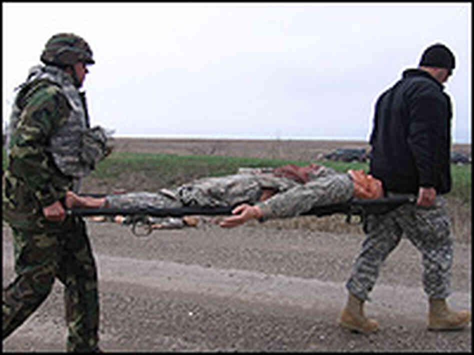 Soldiers carry a dummy on a gurney as part of a training exercise simulating a truck bombing. Soldiers carry a dummy on a gurney as part of a training exercise simulating a truck bombing.