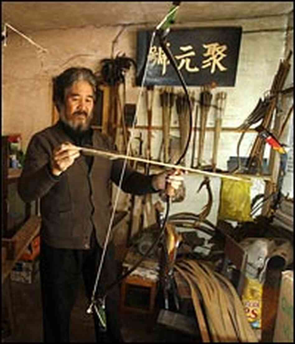 Yang Fuxi holds one of the bow-and-arrow sets he created at his workshop in Beijing.