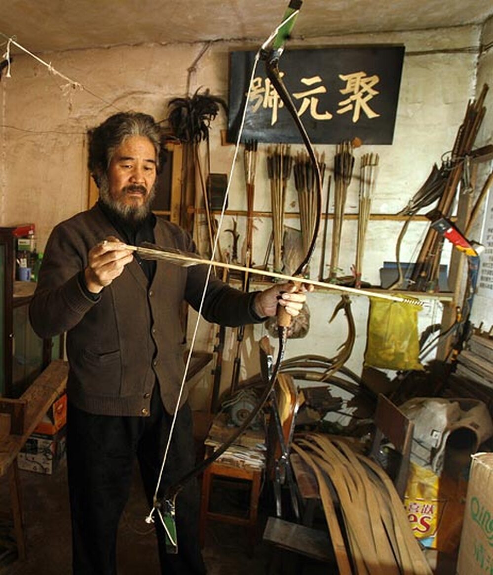 Yang Fuxi holds one of the bow-and-arrow sets he created at his workshop in Beijing.