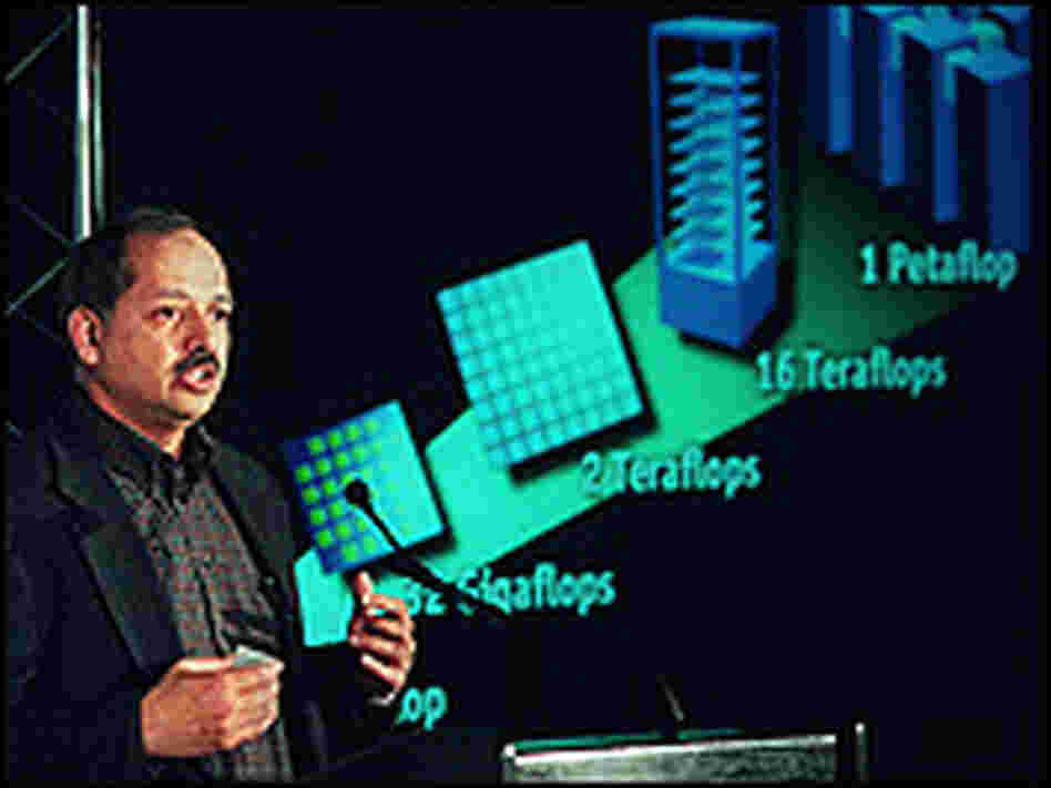 IBM executive stands before a graphic explaining BlueGene computer's power.