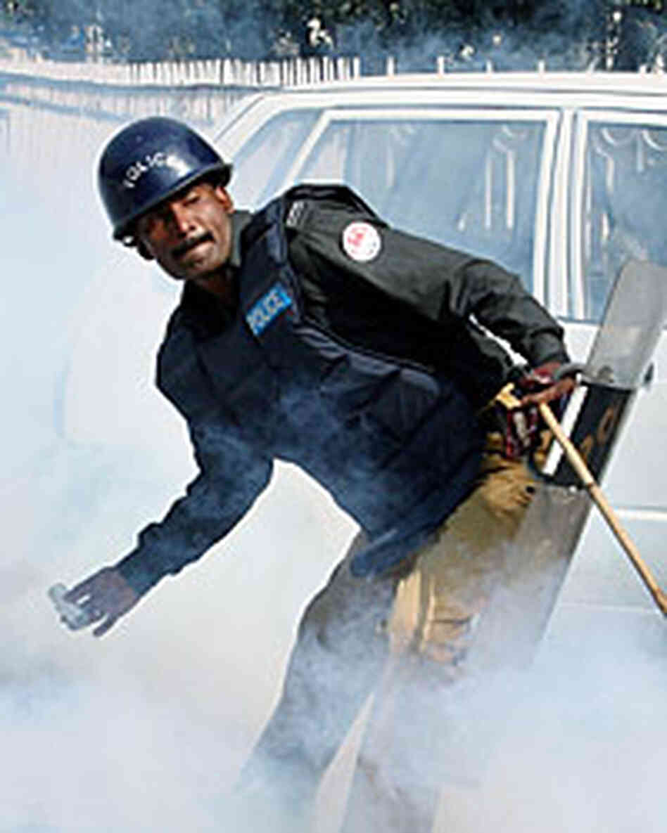 A Pakistani policeman throws a tear-gas shell toward lawyers during a protest in Lahore on Monday. A Pakistani policeman throws a tear-gas shell toward lawyers during a protest in Lahore on Monday.