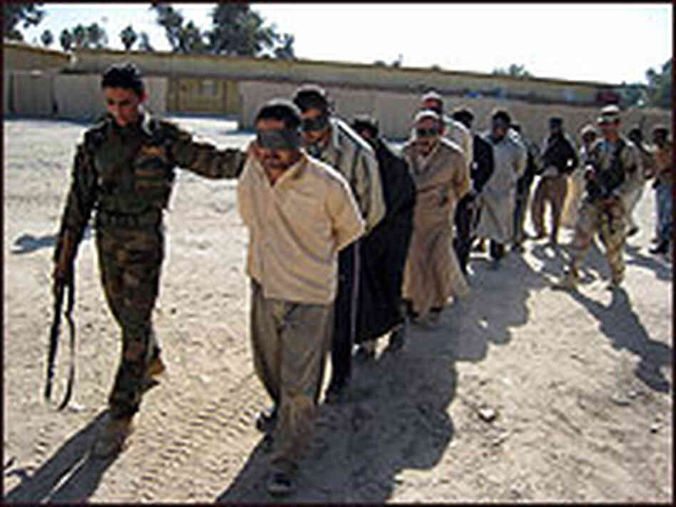 An Iraqi soldier leads blindfolded men, suspected of ties to al-Qaida. An Iraqi soldier leads blindfolded men, suspected of ties to al-Qaida.