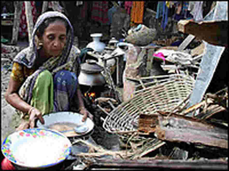 A woman prepares food in front of her destroyed house on the south coast of Bangladesh on Sunday.