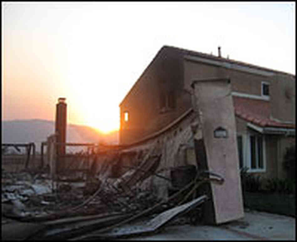 A wildfire claimed a house in the town of Poway while sparing the residence next door.
