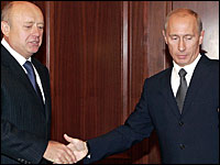 Russian President Vladimir Putin (right) welcomes Prime Minister Mikhail Fradkov during a meeting in Moscow on Wednesday. Putin accepted the Fradkov's resignation, saying that Russia needs to prepare for upcoming parliamentary and presidential elections.