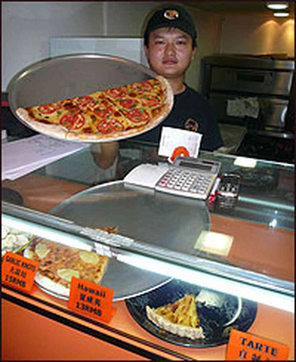 A shopkeeper displays his wares at Shanghai's "New York Pizza Parlor." A shopkeeper displays his wares at Shanghai's "New York Pizza Parlor."