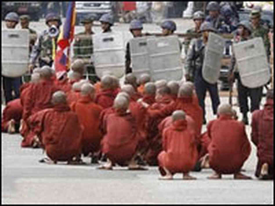 In a photo made available by The Mandalay Gazette, Buddhist monks pray at a road block. In a photo made available by The Mandalay Gazette, Buddhist monks pray at a road block.