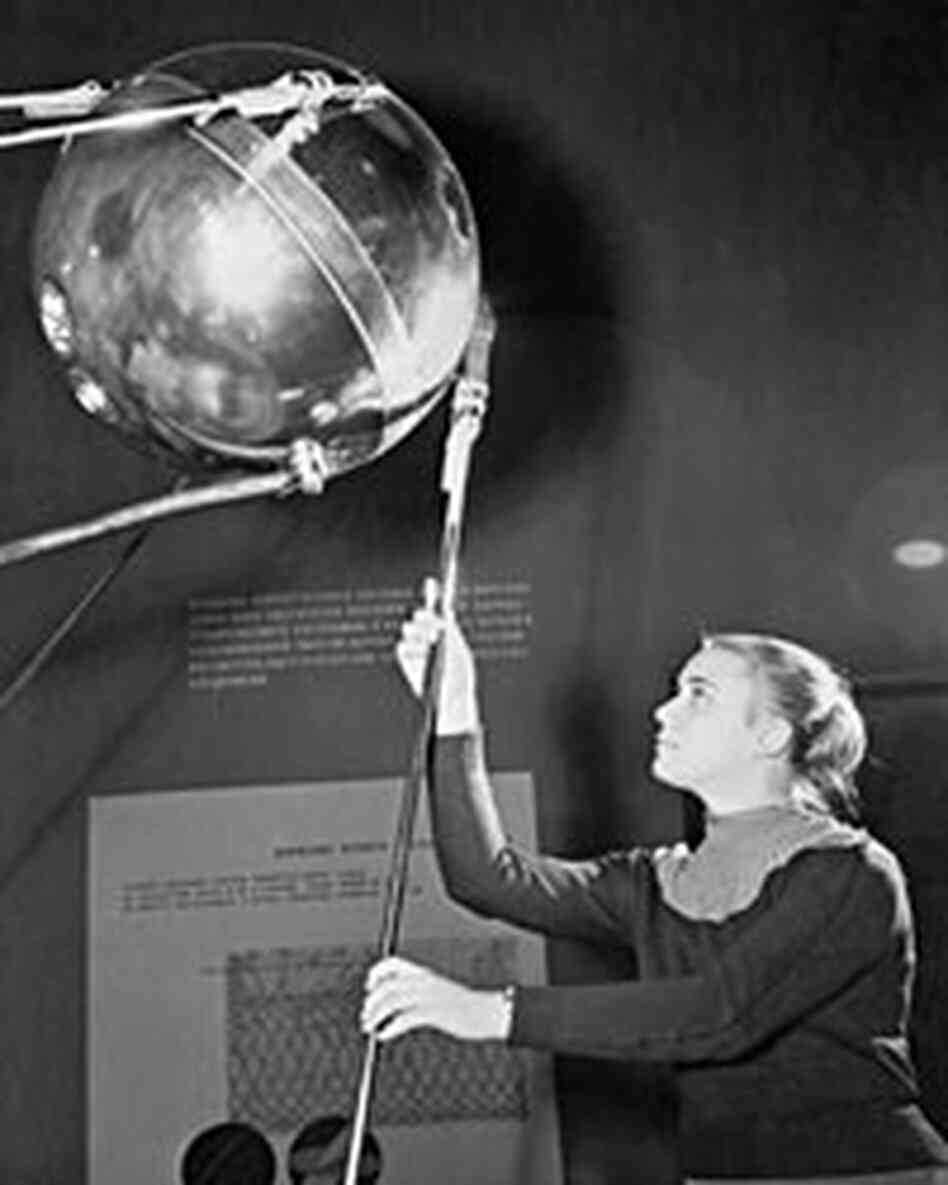 A Russian guide-engineer at a Moscow exhibition displays a replica of Sputnik, Nov. 1957 A Russian guide-engineer at a Moscow exhibition displays a replica of Sputnik, Nov. 1957