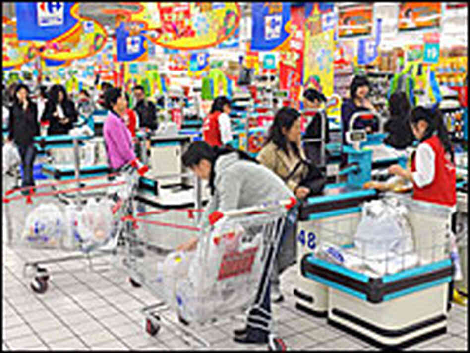 Chinese shoppers stand at the check-out counters inside a supermarket in Shanghai