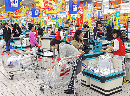 Chinese shoppers stand at the check-out counters inside a supermarket in Shanghai