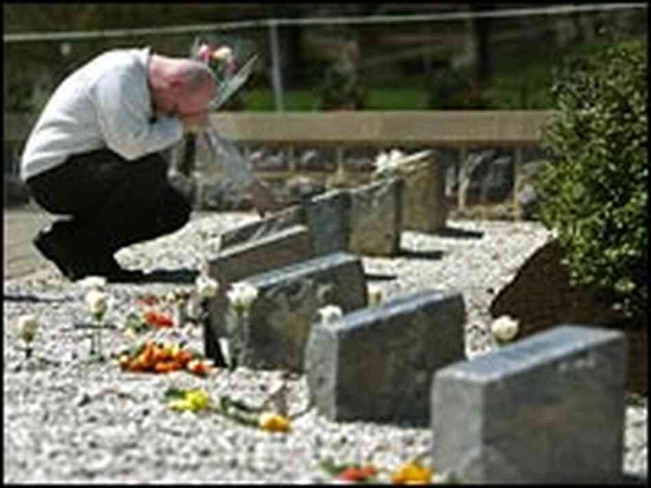 An unidentified man grieves at a memorial to the 32 people killed a year ago at Virginia Tech.