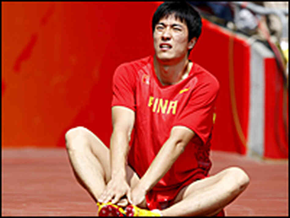 China's Liu Xiang sits on the ground after withdrawing from the 110-meter hurdles.