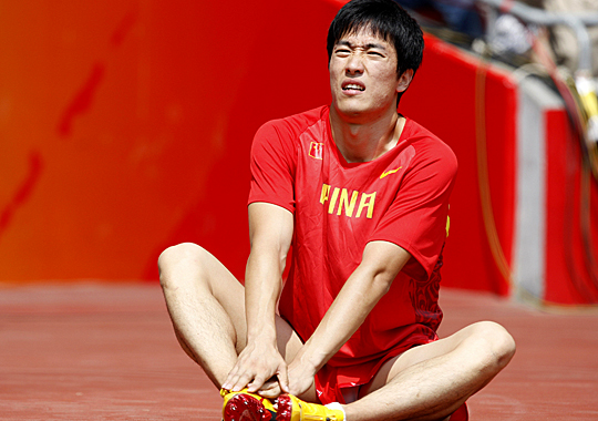 China's Liu Xiang sits on the ground after withdrawing from the 110-meter hurdles.