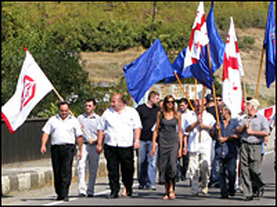 Members of a Georgian labor union march up to a Russian checkpoint.