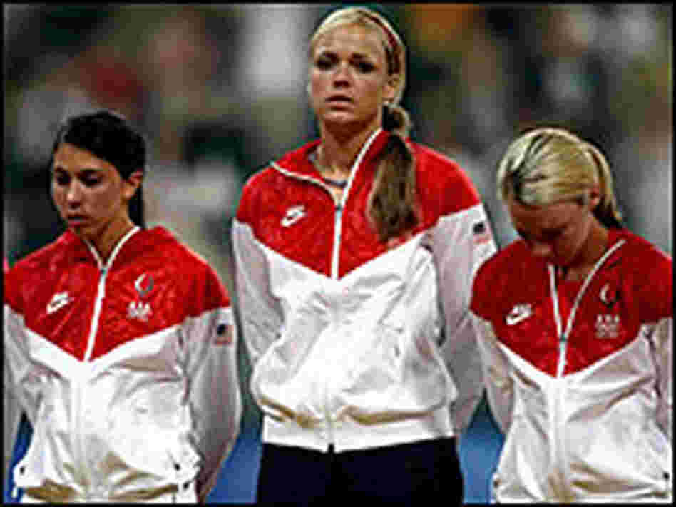U.S. softball players Andrea Duran, Jennie Finch and Caitlin Lowe react to their team's loss.