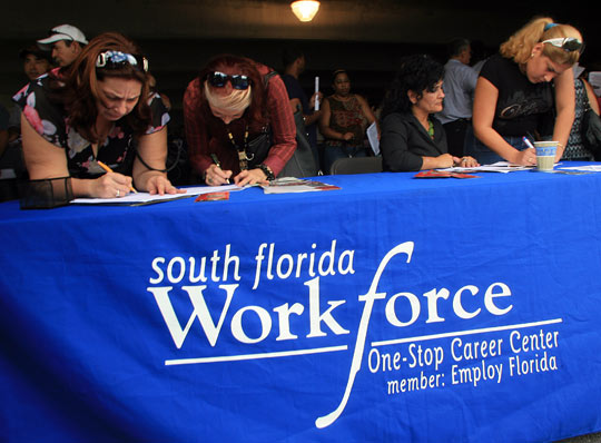 Job seekers register at a job fair attended by thousands Nov. 13 in Hialeah, Fla.
