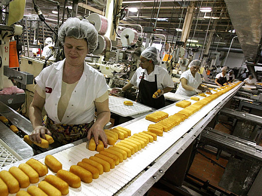 Factory workers preparing Hostess Twinkies for packaging.