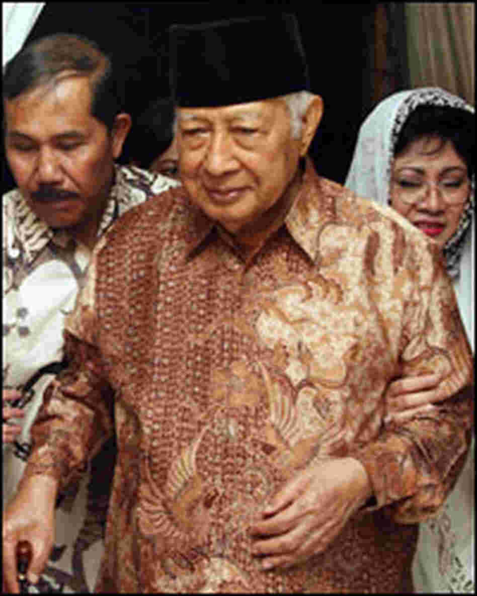 Former Indonesian President Suharto walks with his daughter Siti Hardiyanti Rukmana