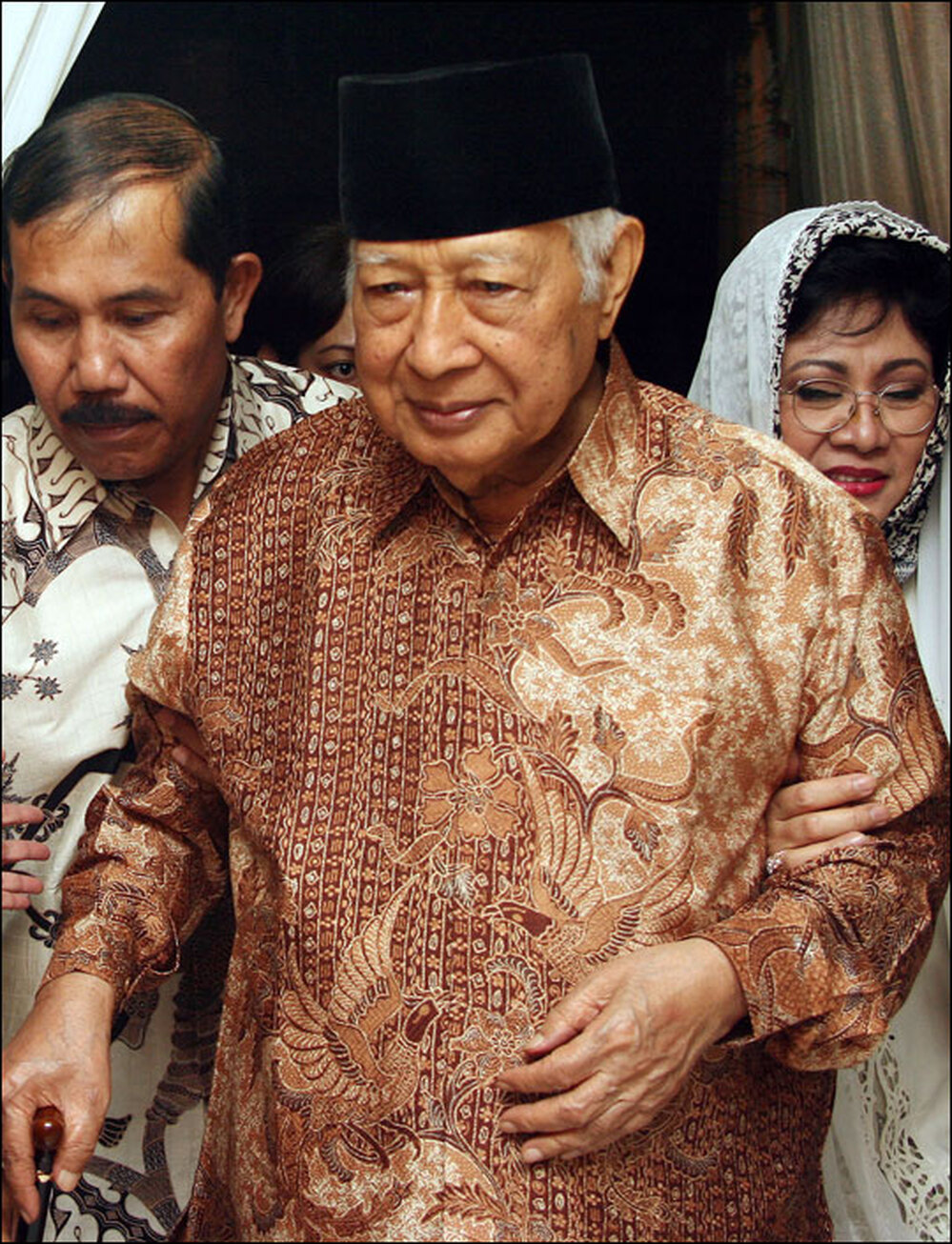 Former Indonesian President Suharto walks with his daughter Siti Hardiyanti Rukmana