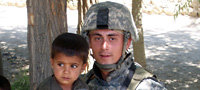 Cpl. Jason Bogar with a boy in Afghanistan.