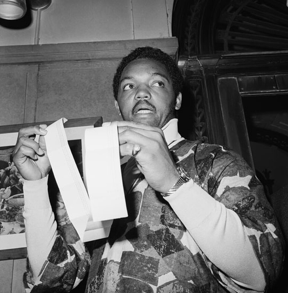 The Rev. Jesse Jackson holds up a lunch bill.