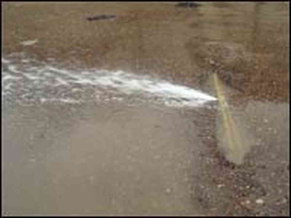 Water spews from a broken pipe in Baghdad.