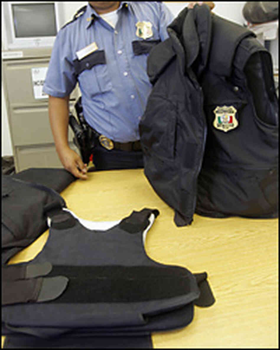 A Juarez police officer displays his bulletproof vest, bought with his own money.