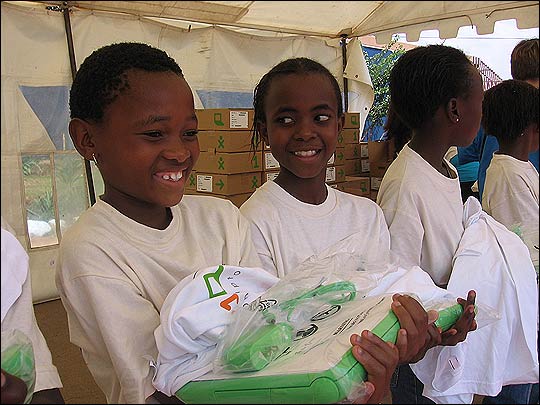 Some young girls smile after receiving their laptops.