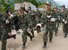 Chinese military race a quake survivor to first aid after pulling him from the rubble in Beichuan, Sichuan province, China, on Friday. Credit: Paula Bronstein/Getty Images